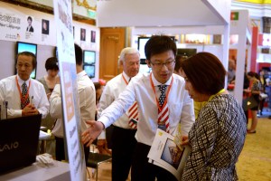 今年5月北京舉辦的一次國際房地產投資展中,一家美國房地產投資公司的職員向一位中國婦女講解。(Getty Images)